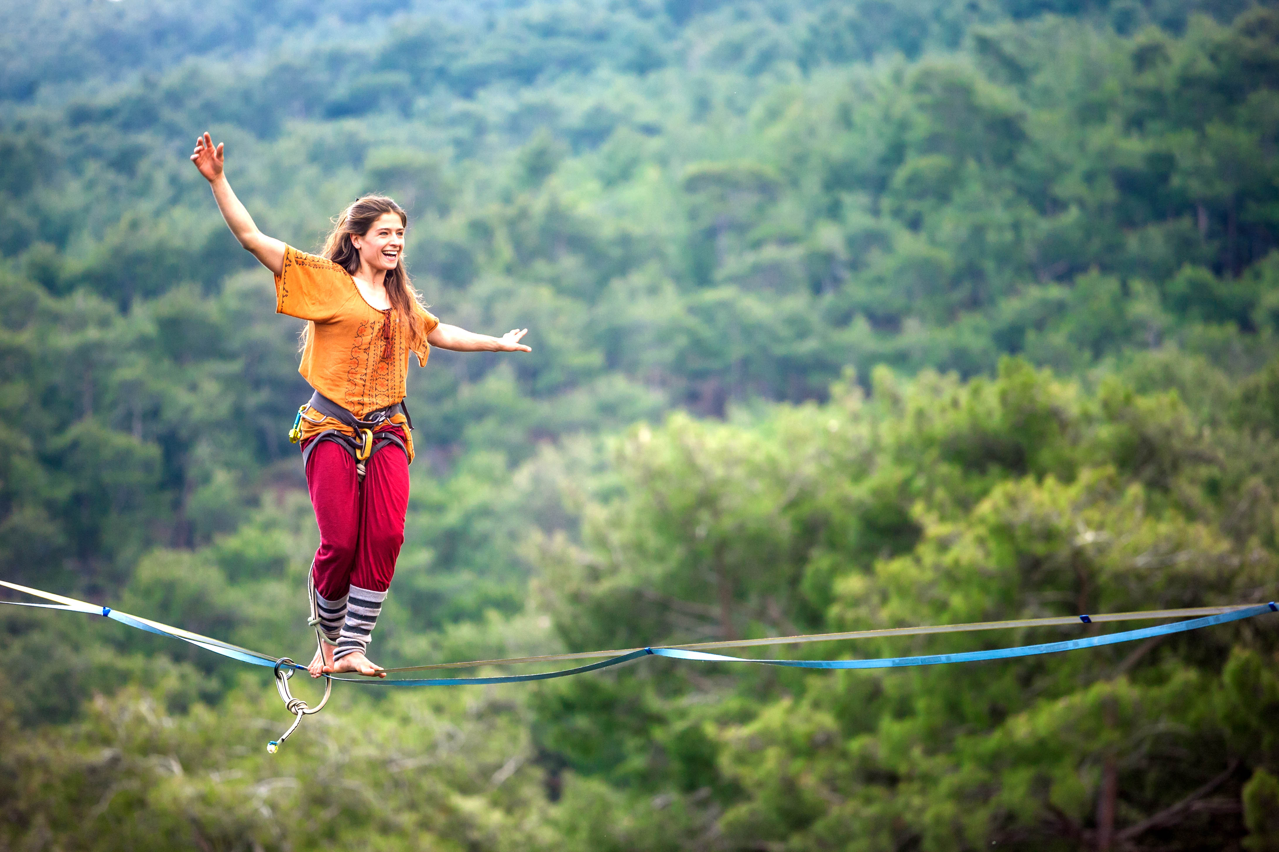 Young ,fit woman walking on a high wire over a canyon Young ,fit woman walking on a high wire over a canyon